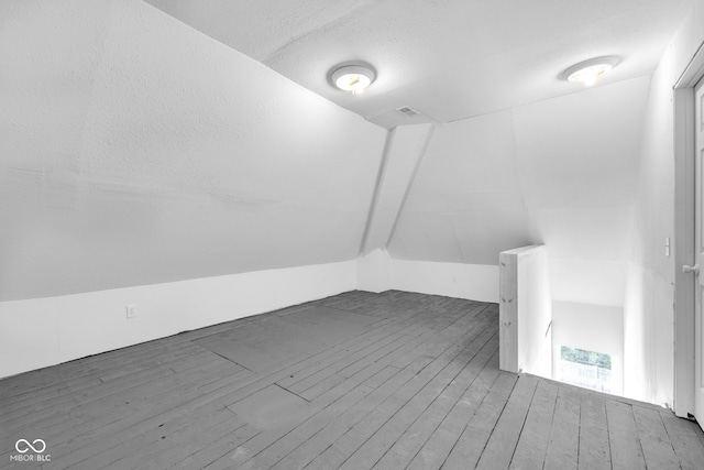 19 E Regent St, Indianapolis, IN 46225 - additional living space featuring wood finished floors, a textured ceiling, and vaulted ceiling