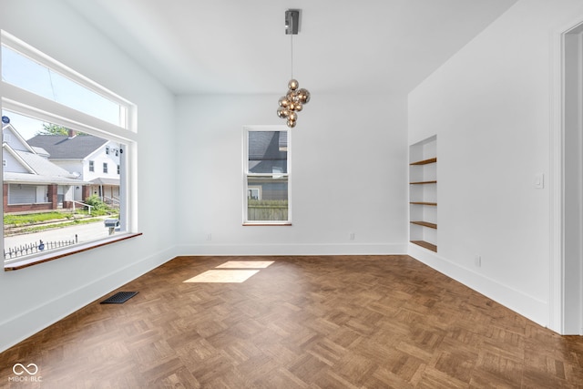 19 E Regent St, Indianapolis, IN 46225 - empty room featuring baseboards, built in features, and a chandelier