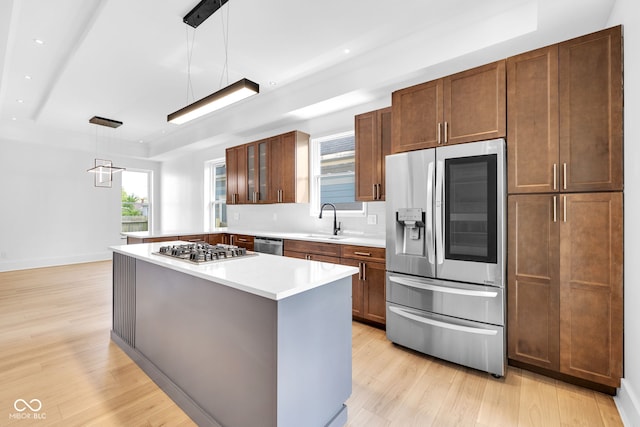 19 E Regent St, Indianapolis, IN 46225 - kitchen with appliances with stainless steel finishes, a raised ceiling, a sink, light wood-style flooring, and light countertops