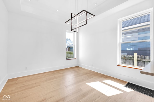 19 E Regent St, Indianapolis, IN 46225 - unfurnished dining area featuring healthy amount of natural light, light wood-type flooring, baseboards, and a chandelier