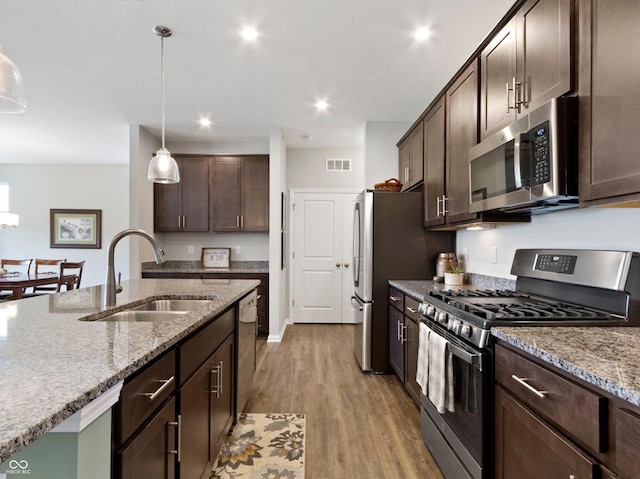 19657 Astoria Ave, Sheridan, IN 46069 - kitchen with stainless steel appliances, a sink, dark brown cabinetry, light wood-type flooring, and recessed lighting