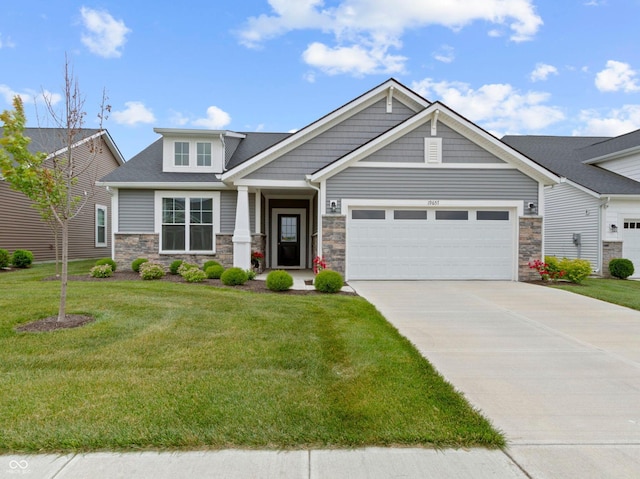 19657 Astoria Ave, Sheridan, IN 46069 - craftsman house featuring stone siding, an attached garage, concrete driveway, and a front lawn