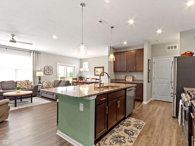 19657 Astoria Ave, Sheridan, IN 46069 - kitchen featuring a sink, open floor plan, stainless steel appliances, a kitchen island with sink, and wood finished floors