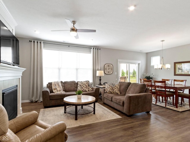 19657 Astoria Ave, Sheridan, IN 46069 - living area featuring ceiling fan, dark wood-type flooring, a chandelier, and a tiled fireplace