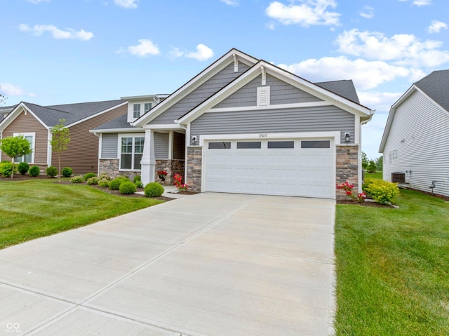19657 Astoria Ave, Sheridan, IN 46069 - craftsman-style house with stone siding, a front yard, concrete driveway, and an attached garage