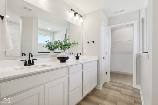 2693 Penn Ave, Plainfield, IN 46168 - full bathroom featuring double vanity, a spacious closet, and wood finished floors