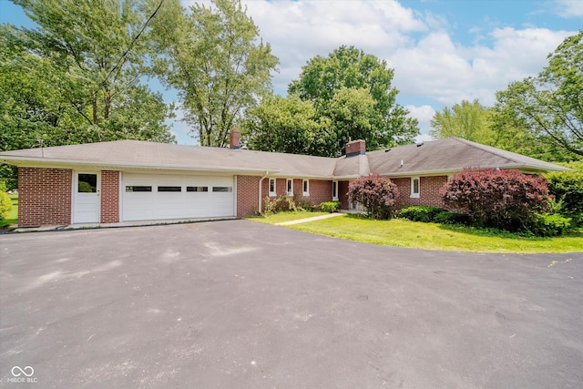 4232 Linden Ln, Anderson, IN 46011 - ranch-style house featuring asphalt driveway, a garage, brick siding, and a chimney