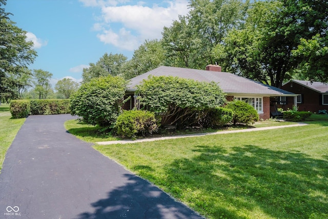 4232 Linden Ln, Anderson, IN 46011 - view of front facade with a chimney, a front yard, and brick siding