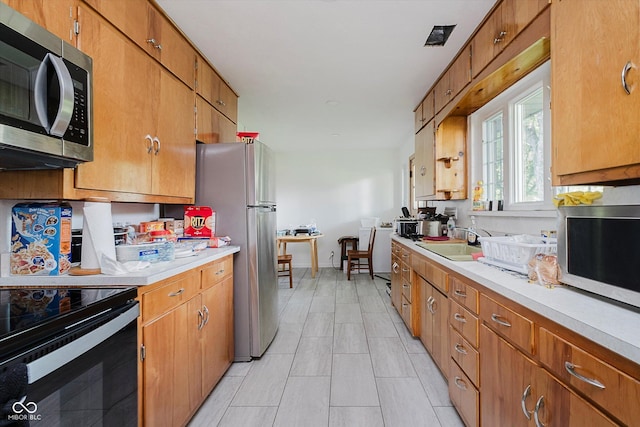 4232 Linden Ln, Anderson, IN 46011 - kitchen featuring stainless steel appliances, light countertops, and brown cabinets