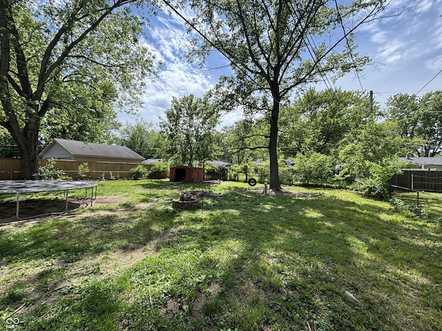 2015 Rosewood Dr, Anderson, IN 46011 - view of yard featuring a trampoline, a storage shed, and an outbuilding