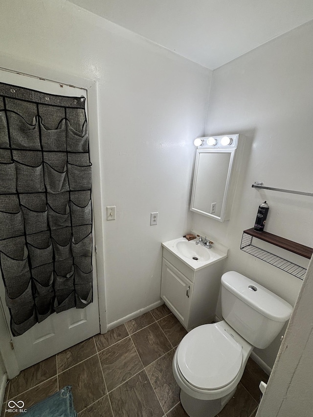 2015 Rosewood Dr, Anderson, IN 46011 - bathroom with toilet, vanity, and baseboards