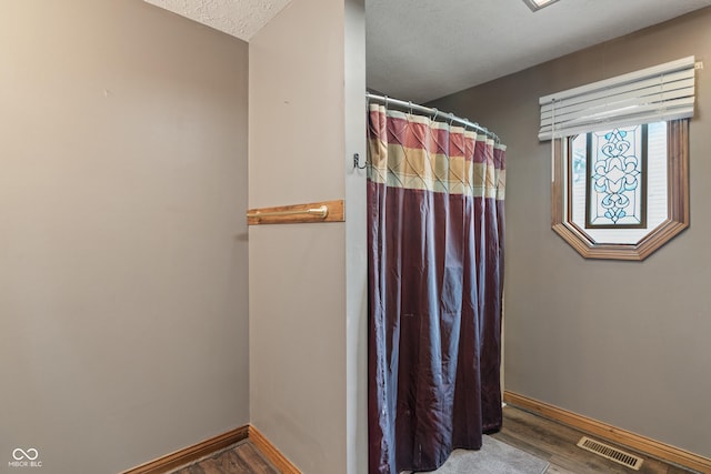485 Mesa Dr, Russiaville, IN 46979 - bathroom featuring wood finished floors, baseboards, curtained shower, and a textured ceiling