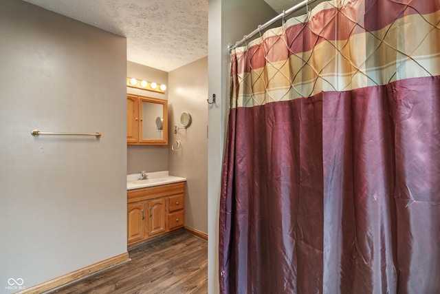 485 Mesa Dr, Russiaville, IN 46979 - bathroom featuring a textured ceiling, wood finished floors, vanity, baseboards, and curtained shower
