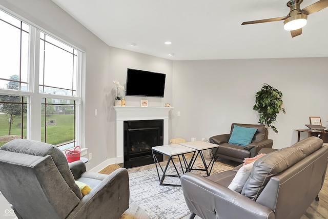 8266 Glacier Ridge Dr, Fishers, IN 46038 - living room with light wood-style flooring, ceiling fan, a fireplace with flush hearth, recessed lighting, and baseboards