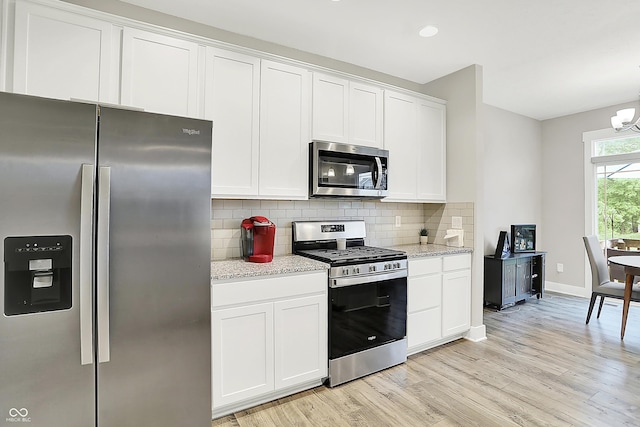 8266 Glacier Ridge Dr, Fishers, IN 46038 - kitchen featuring stainless steel appliances, light wood-style flooring, decorative backsplash, a chandelier, and white cabinetry