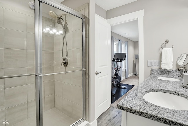 8266 Glacier Ridge Dr, Fishers, IN 46038 - bathroom with a shower stall, baseboards, double vanity, and wood finished floors