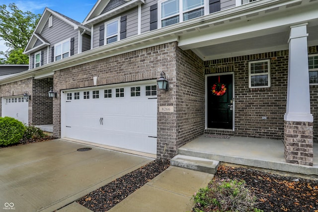 8266 Glacier Ridge Dr, Fishers, IN 46038 - view of exterior entry featuring brick siding, a garage, and concrete driveway