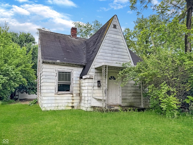 2606 Raible Ave, Anderson, IN 46011 - rear view of property featuring a chimney, a lawn, and roof with shingles