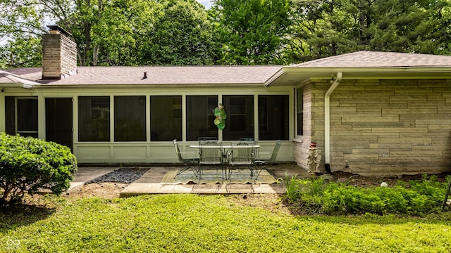 6220 Spring Mill Rd, Indianapolis, IN 46260 - rear view of house with a chimney, a patio area, stone siding, a sunroom, and a shingled roof