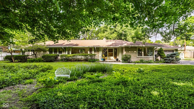 6220 Spring Mill Rd, Indianapolis, IN 46260 - ranch-style home featuring a garage, a front yard, a chimney, and stone siding