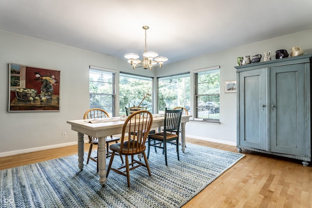 6220 Spring Mill Rd, Indianapolis, IN 46260 - dining area with a chandelier, light wood finished floors, and baseboards