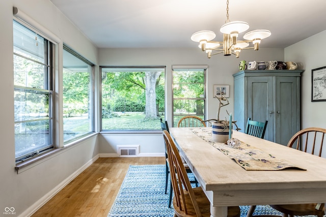 6220 Spring Mill Rd, Indianapolis, IN 46260 - dining room featuring healthy amount of natural light, a chandelier, light wood-style flooring, and baseboards