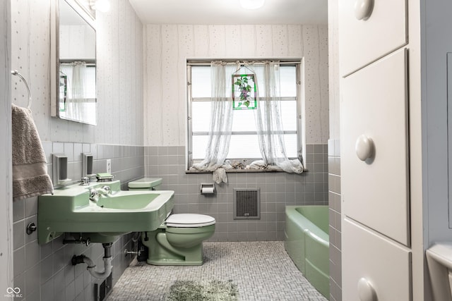 6220 Spring Mill Rd, Indianapolis, IN 46260 - bathroom with wallpapered walls, wainscoting, toilet, tile walls, and a bath