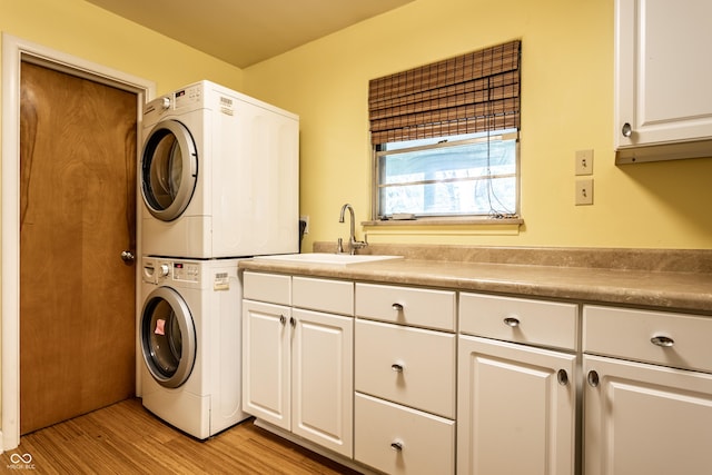 6220 Spring Mill Rd, Indianapolis, IN 46260 - laundry room featuring stacked washer / drying machine, cabinet space, and light wood finished floors