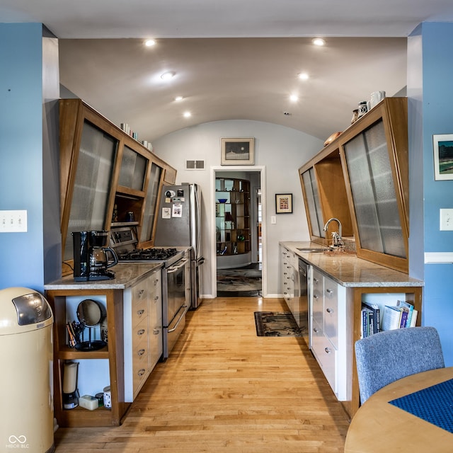 6220 Spring Mill Rd, Indianapolis, IN 46260 - kitchen featuring stainless steel appliances, a sink, light wood-style flooring, glass insert cabinets, and lofted ceiling