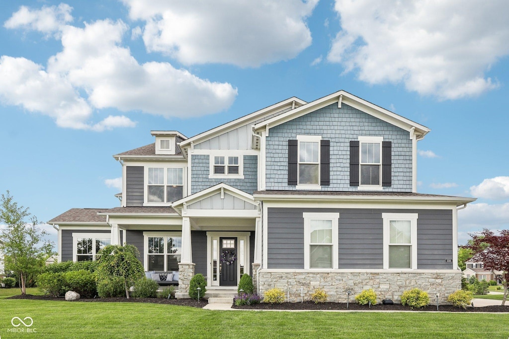 3316 Shelborne Woods Pkwy, Carmel, IN 46032 - craftsman-style home with stone siding, a front yard, and board and batten siding