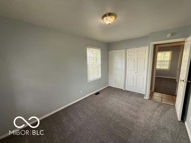 7842 Brennan Rd, Indianapolis, IN 46219 - unfurnished bedroom featuring carpet flooring, baseboards, and a closet