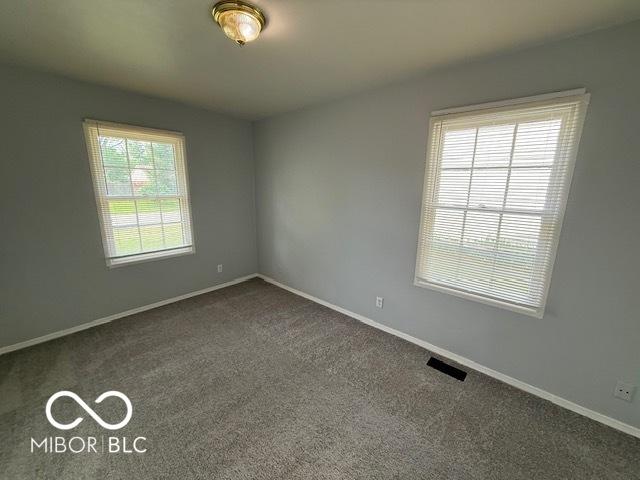 7842 Brennan Rd, Indianapolis, IN 46219 - empty room featuring dark carpet and baseboards