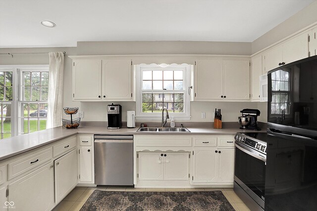 6605 Grosvenor Pl, Indianapolis, IN 46220 - kitchen featuring appliances with stainless steel finishes, a sink, light tile patterned floors, white cabinetry, and recessed lighting