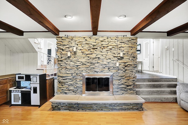 6605 Grosvenor Pl, Indianapolis, IN 46220 - living room featuring beam ceiling, light wood-type flooring, stairway, crown molding, and wooden walls