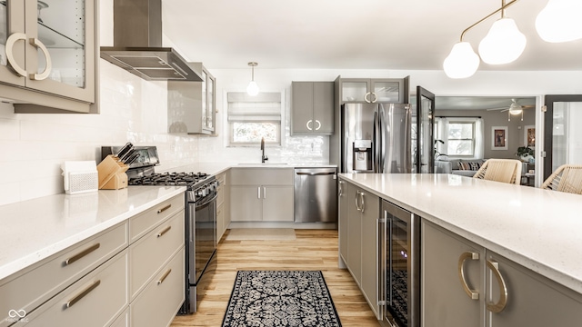 7110 N Layman Ave, Indianapolis, IN 46250 - kitchen featuring appliances with stainless steel finishes, wall chimney exhaust hood, gray cabinets, and beverage cooler
