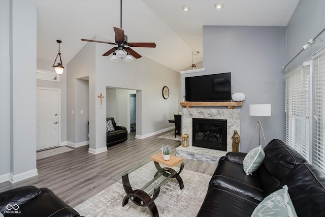 7838 Chesapeake Dr E, Indianapolis, IN 46236 - living area with high vaulted ceiling, a ceiling fan, baseboards, a stone fireplace, and wood finished floors