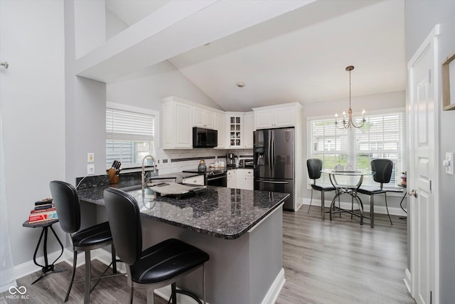 7838 Chesapeake Dr E, Indianapolis, IN 46236 - kitchen with refrigerator with ice dispenser, black microwave, a peninsula, glass insert cabinets, and electric range