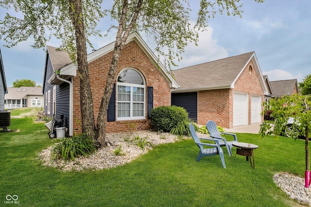 7838 Chesapeake Dr E, Indianapolis, IN 46236 - back of property with brick siding, a yard, roof with shingles, and a garage