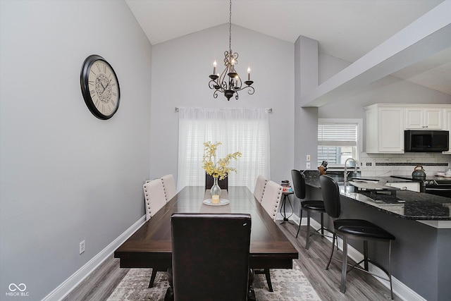 7838 Chesapeake Dr E, Indianapolis, IN 46236 - dining area featuring a chandelier, wood finished floors, baseboards, and high vaulted ceiling