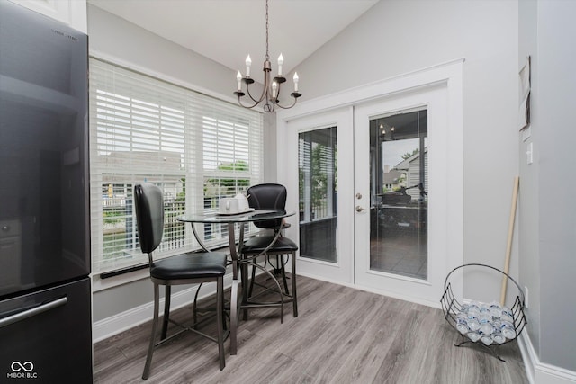 7838 Chesapeake Dr E, Indianapolis, IN 46236 - dining room with french doors, lofted ceiling, a chandelier, wood finished floors, and baseboards