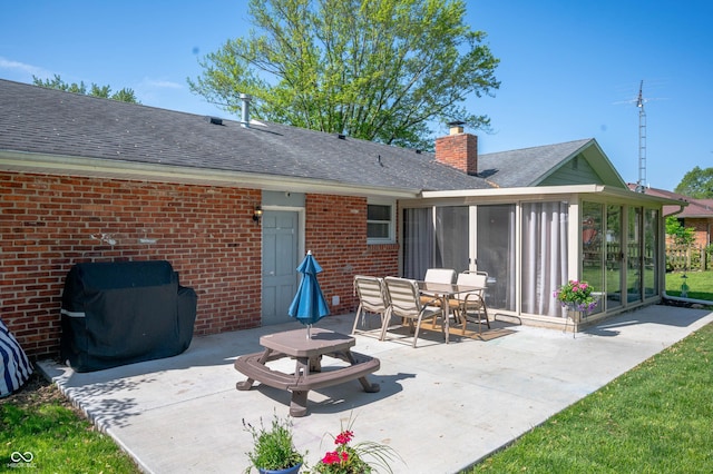 9104 W Lone Beech Dr, Muncie, IN 47304 - rear view of property with a sunroom, brick siding, a patio area, and a shingled roof