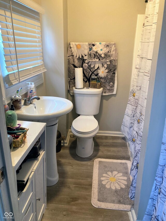 1114 N Olney St, Indianapolis, IN 46201 - bathroom featuring wood finished floors, toilet, and baseboards