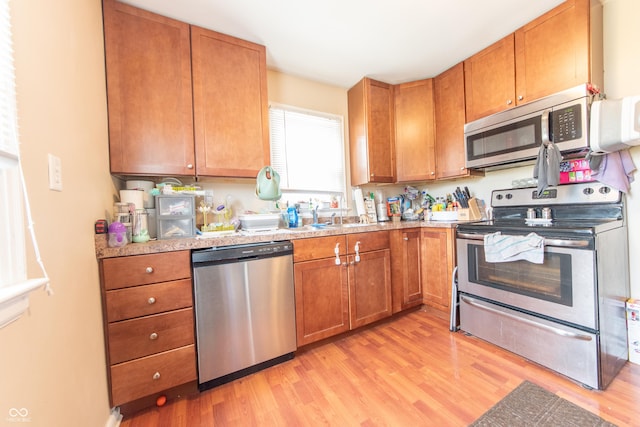 1913 Pennsylvania St, Columbus, IN 47201 - kitchen featuring appliances with stainless steel finishes, light wood finished floors, brown cabinetry, and light countertops