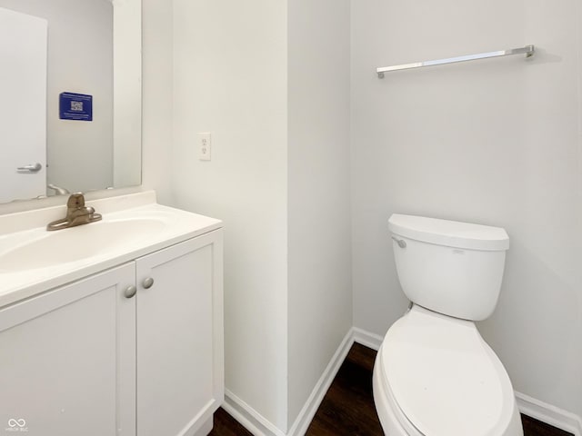 2116 Orchid Bloom Dr, Indianapolis, IN 46231 - half bathroom with toilet, vanity, wood finished floors, and baseboards