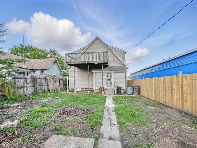 2006 N Olney St, Indianapolis, IN 46218 - back of house with a fenced backyard, a balcony, and entry steps