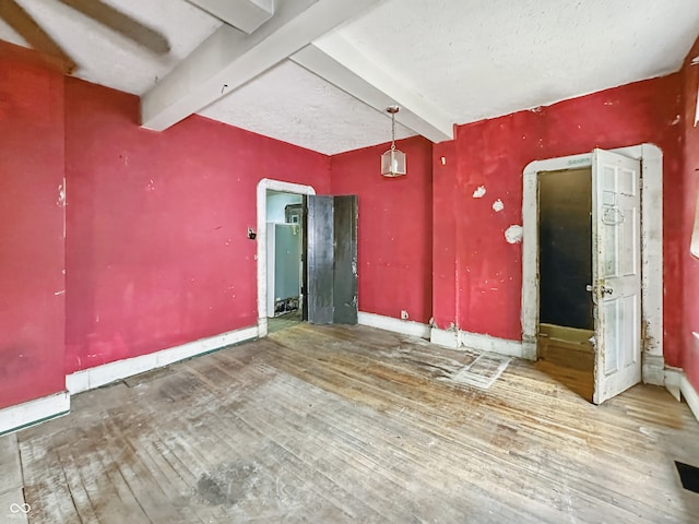 2006 N Olney St, Indianapolis, IN 46218 - spare room featuring beamed ceiling, hardwood / wood-style flooring, and baseboards