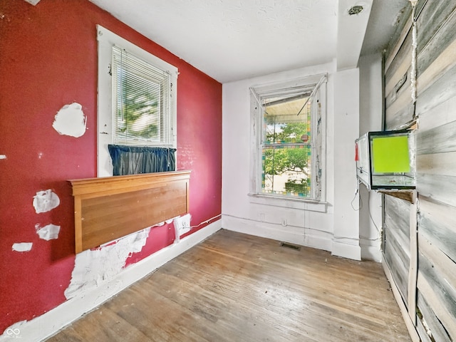 2006 N Olney St, Indianapolis, IN 46218 - unfurnished bedroom featuring wood finished floors, baseboards, and a textured ceiling