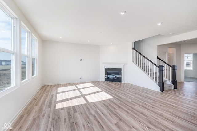 18967 Seaforth Way, Westfield, IN 46074 - unfurnished living room with a fireplace, light wood-style flooring, stairs, recessed lighting, and baseboards