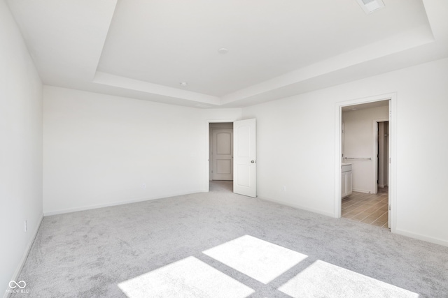 18967 Seaforth Way, Westfield, IN 46074 - unfurnished bedroom featuring a tray ceiling, light colored carpet, baseboards, and ensuite bath