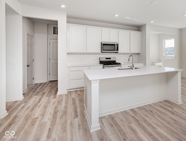 18967 Seaforth Way, Westfield, IN 46074 - kitchen with stainless steel appliances, a sink, decorative backsplash, light wood-style flooring, and recessed lighting